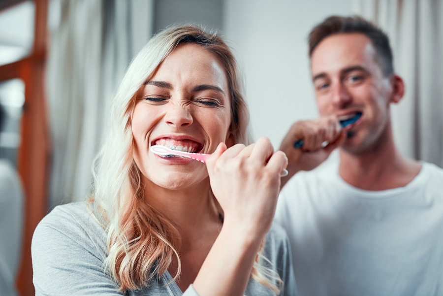 Eine Frau und ein Mann putzen sich gemeinsam die Zähne